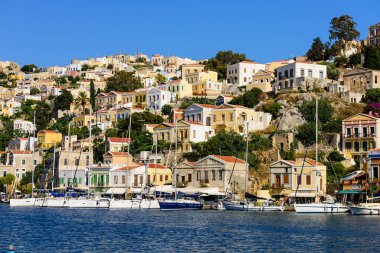 Suriye adası, Dodecanese Adaları, Yunanistan - 18 Mayıs 2016: Parlak ve renkli balıkçı tekneleriyle Yunanistan 'ın Symi adasındaki manzara kıyısı