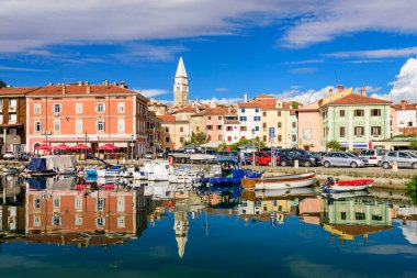 Izola, Slovenya - 20 Eylül 2016: Izola 'da deniz kıyısında tekneleri ve parlak renkli evleri olan manzaralı liman. Slovenya 'yı gezmek, popüler turizm beldesi