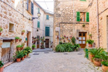 Mallorca Adası, Balearic Adaları, İspanya - 4 Ocak 2019: Valldemossa eski kasabasında çiçeklerle süslenmiş taş binalarla dolu güzel bir cadde