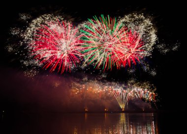 nehir su yansıması ile yukarıda gece gökyüzü üzerinde renkli havai fişek 