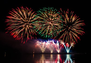 nehir su yansıması ile yukarıda gece gökyüzü üzerinde renkli havai fişek 