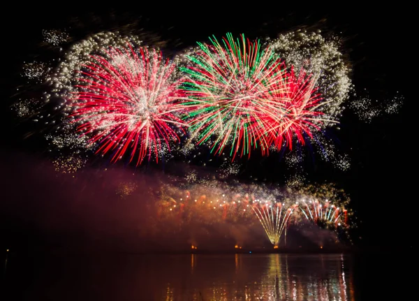 nehir su yansıması ile yukarıda gece gökyüzü üzerinde renkli havai fişek 