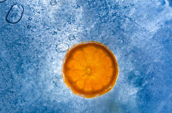 Gros Plan Tranches Congelées Fruits Orange Dans Glace Bleue — Photo