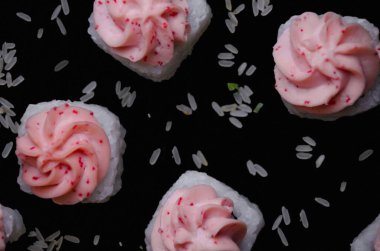 Siyah arka planda pirinçle birlikte beyaz suşi lavında uçuyorlar.