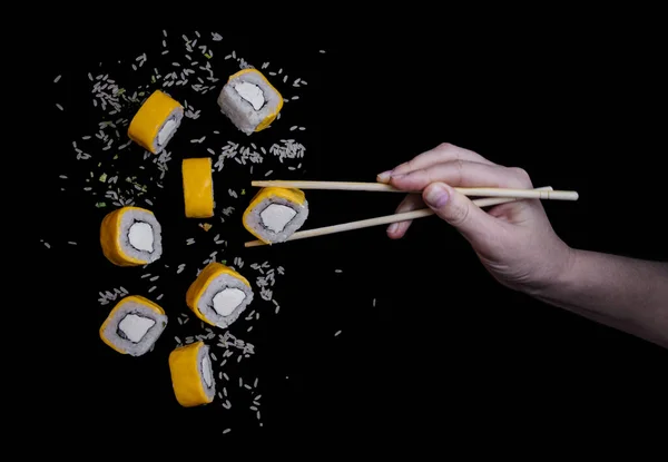 Flying Yellow Cheddar Sushi Rice Black Background Close Hand Bamboo — Stock Photo, Image