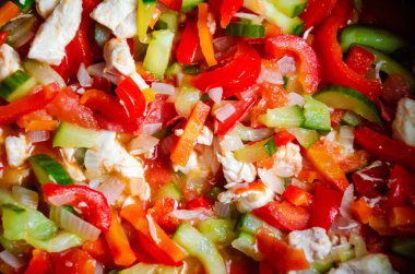 Lezzetli taze sebzeler kırmızı çan biberi soğanlı salatalık domates kabağı doğranmış havuç ve üzerine dereotu serpiştirilmiş kızartılmış üst manzara.