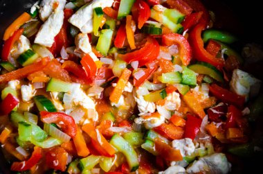 Lezzetli taze sebzeler kırmızı çan biberi soğanlı salatalık domates kabağı doğranmış havuç ve üzerine dereotu serpiştirilmiş kızartılmış üst manzara.