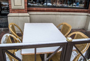 Masa ve sandalyeler karla kaplı.