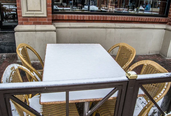 Masa ve sandalyeler karla kaplı.
