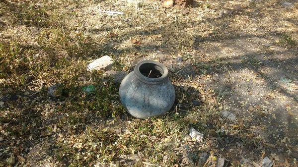 Hindistan 'ın kırsal kesimlerinde çamurla dolu eski kullanılmamış toprak tenceresi.