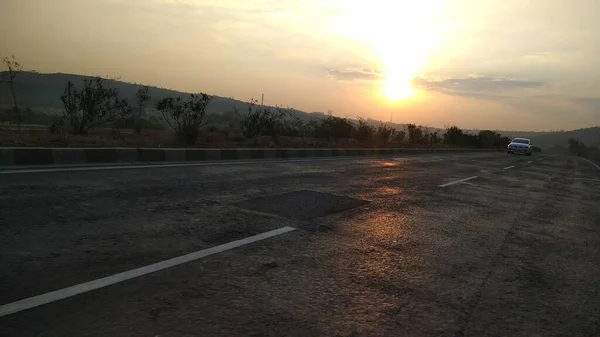 インドのオレンジ色の空を背景にした国道での朝の日の出 — ストック写真