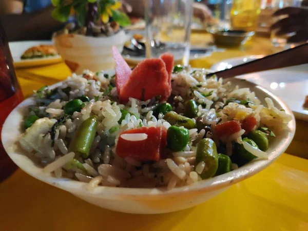Masala pilavı güzelce süslenmiş ve Hint baharatları ve sebzeleriyle restoranda servis edilmiş.