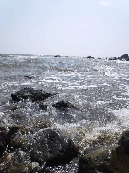 Hindistan Kunkunkunkuneshwar Konkan Maharashtra 'da Arap denizinin güzel deniz suyuyla kumsaldaki taşlar.