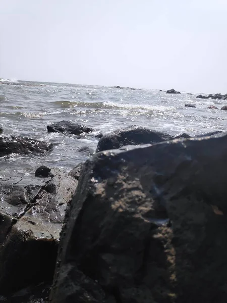 Hindistan Kunkunkunkuneshwar Konkan Maharashtra 'da Arap denizinin güzel deniz suyuyla kumsaldaki taşlar.