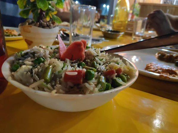 Masala pilavı güzelce süslenmiş ve Hint baharatları ve sebzeleriyle restoranda servis edilmiş.
