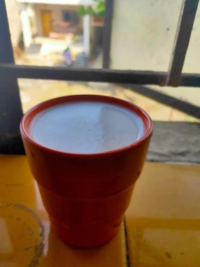 Portakal suyu tamamen elmalı sütle dolu. Gün ışığında pencerede tutulur.