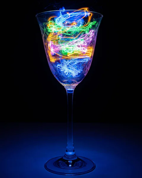 Şarap kadehinin içinde hafif bir fırtına var. Siyah arka plan, sade fotoğrafçılık. Soyut yıldırım içeceği,