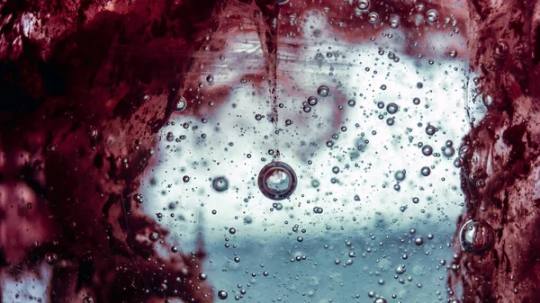 Kırmızı boyayla karıştırılmış şeffaf sabuna sıkışan büyük hava kabarcığı.