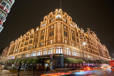 Londra 'daki Harrods Mağazası yakınlarındaki Birleşik Krallık' ta tipik bir yağmurlu günde gece trafiği ve sokak manzarası. Londra, İngiltere 'de kış döneminde gece şehir manzarası.