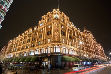 Londra 'daki Harrods Mağazası yakınlarındaki Birleşik Krallık' ta tipik bir yağmurlu günde gece trafiği ve sokak manzarası. Londra, İngiltere 'de kış döneminde gece şehir manzarası.