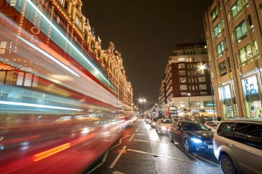 Londra 'daki Harrods Mağazası yakınlarındaki Birleşik Krallık' ta tipik bir yağmurlu günde gece trafiği ve sokak manzarası. Londra, İngiltere 'de kış döneminde gece şehir manzarası.
