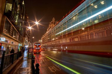 Londra 'daki Harrods Mağazası yakınlarındaki Birleşik Krallık' ta tipik bir yağmurlu günde gece trafiği ve sokak manzarası. Londra, İngiltere 'de kış döneminde gece şehir manzarası.