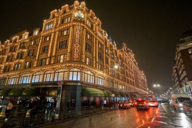 Londra 'daki Harrods Mağazası yakınlarındaki Birleşik Krallık' ta tipik bir yağmurlu günde gece trafiği ve sokak manzarası. Londra, İngiltere 'de kış döneminde gece şehir manzarası.
