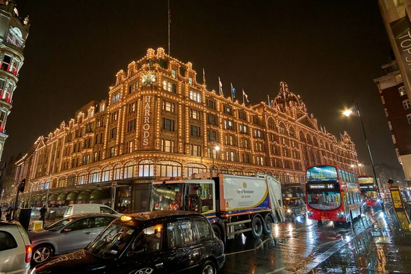 夜の交通とロンドンのハロッズデパートの近くにイギリスで典型的な雨の日の通りの風景 ロンドン イギリスの冬の間の夜の都市シーン — ストック写真