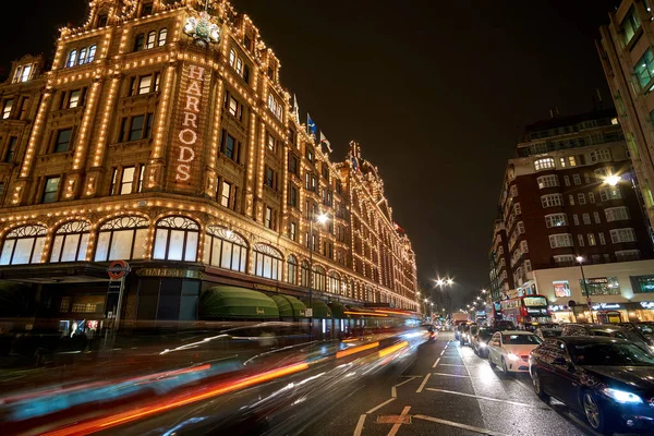 夜の交通とロンドンのハロッズデパートの近くにイギリスで典型的な雨の日の通りの風景 ロンドン イギリスの冬の間の夜の都市シーン — ストック写真