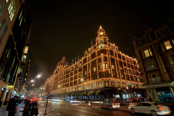 夜の交通とロンドンのハロッズデパートの近くにイギリスで典型的な雨の日の通りの風景 ロンドン イギリスの冬の間の夜の都市シーン — ストック写真