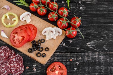 Hamur ve üretime pizza sebze hazırlanması. Ahşap arka plan üzerinde pizza üretimi için malzemeler