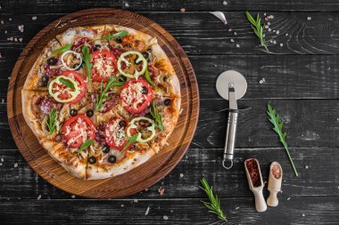 Siyah ahşap zemin sebze, mantar ve domates pizza. Arka plan olarak kullanılabilir