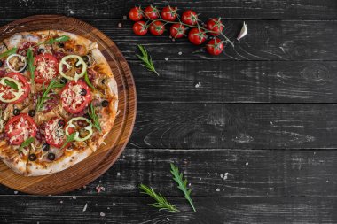 Siyah ahşap zemin sebze, mantar ve domates pizza. Arka plan olarak kullanılabilir