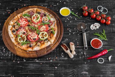 Siyah ahşap zemin sebze, mantar ve domates pizza. Arka plan olarak kullanılabilir