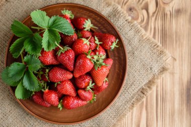 Ahşap bir masada lezzetli çilek. Arkaplan olarak kullanılabilir.