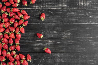 Ahşap bir masada lezzetli çilek. Arkaplan olarak kullanılabilir.