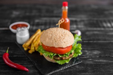 Et ve sebze karanlık bir arka plan ile lezzetli hamburger. Fast food. Arka plan olarak kullanılabilir