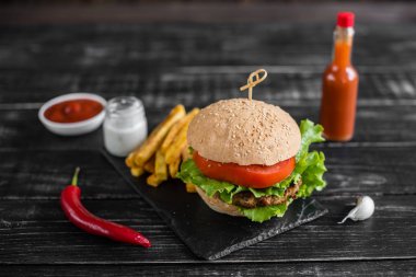 Et ve sebze karanlık bir arka plan ile lezzetli hamburger. Fast food. Arka plan olarak kullanılabilir