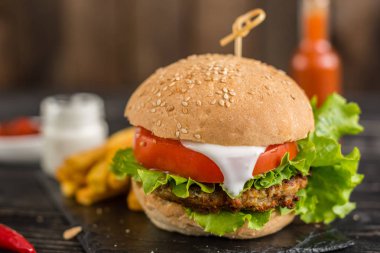 Et ve sebze karanlık bir arka plan ile lezzetli hamburger. Fast food. Arka plan olarak kullanılabilir