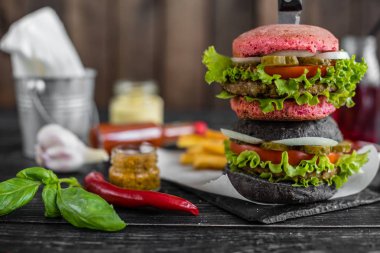 Et ve sebze karanlık bir arka plan ile lezzetli hamburger. Fast food. Arka plan olarak kullanılabilir