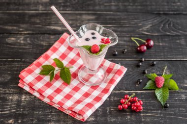 Ahududu farklı meyve ahşap bir zemin üzerine bir bardak dan güler yüzlü. Arka plan olarak kullanılabilir