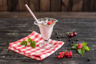 Ahududu farklı meyve ahşap bir zemin üzerine bir bardak dan güler yüzlü. Arka plan olarak kullanılabilir