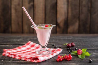 Ahududu farklı meyve ahşap bir zemin üzerine bir bardak dan güler yüzlü. Arka plan olarak kullanılabilir