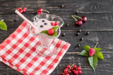 Ahududu farklı meyve ahşap bir zemin üzerine bir bardak dan güler yüzlü. Arka plan olarak kullanılabilir