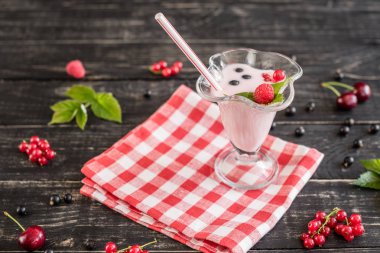 Ahududu farklı meyve ahşap bir zemin üzerine bir bardak dan güler yüzlü. Arka plan olarak kullanılabilir