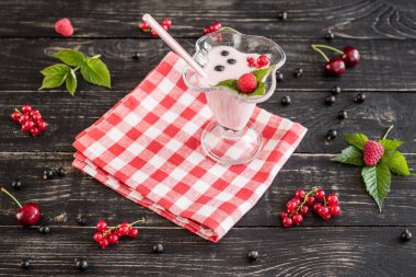 Ahududu farklı meyve ahşap bir zemin üzerine bir bardak dan güler yüzlü. Arka plan olarak kullanılabilir