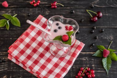 Ahududu farklı meyve ahşap bir zemin üzerine bir bardak dan güler yüzlü. Arka plan olarak kullanılabilir