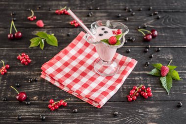 Ahududu farklı meyve ahşap bir zemin üzerine bir bardak dan güler yüzlü. Arka plan olarak kullanılabilir