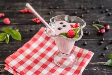 Ahududu farklı meyve ahşap bir zemin üzerine bir bardak dan güler yüzlü. Arka plan olarak kullanılabilir