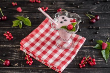 Ahududu farklı meyve ahşap bir zemin üzerine bir bardak dan güler yüzlü. Arka plan olarak kullanılabilir